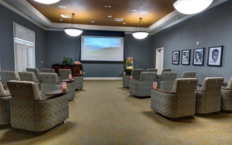 a room with a large screen and chairs