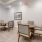 a room with a table chairs and a painting on the wall