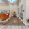 a room with a wood floor and orange chairs